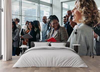 Business professionals interacting and laughing during a lively corporate event Wall mural