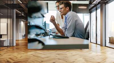 Business professionals looking at computer monitor Wall mural