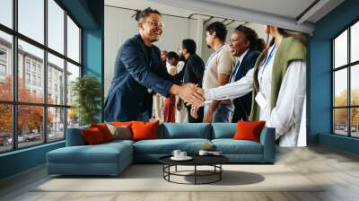 Business professionals shaking hands and networking in an office setting Wall mural