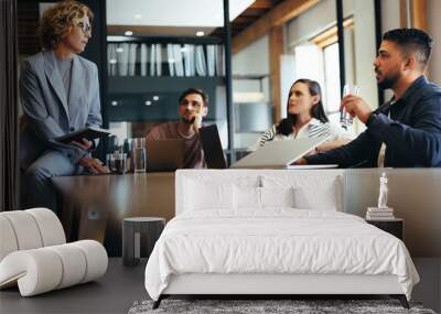 Business team discussing a project in a meeting. Group of business people sitting and talking in a boardroom Wall mural