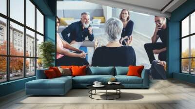 Business team sitting in circle and discussing Wall mural