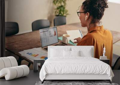 Business woman working on laptop at home office Wall mural