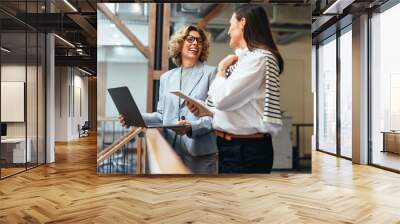 Business women smiling as they have a meeting on a balcony Wall mural