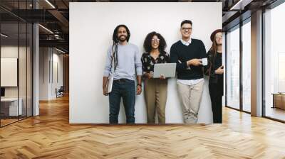 Businessman holding a coffee cup standing with coworkers in offi Wall mural