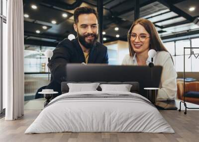 Businessman showing his colleague something on a laptop Wall mural