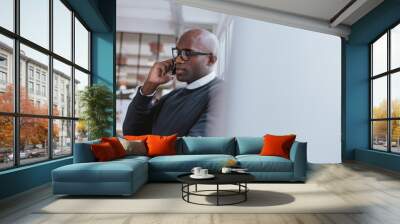 Businessman talking on cellphone while at work Wall mural