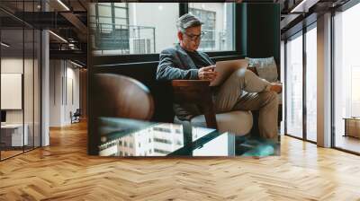 Businessman working in office lounge Wall mural