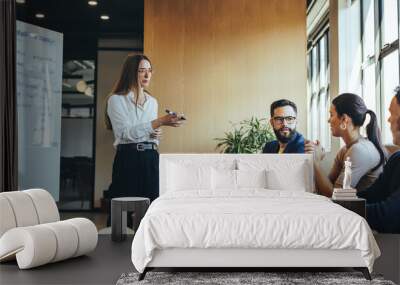 Businesswoman discussing her marketing strategy with her team Wall mural