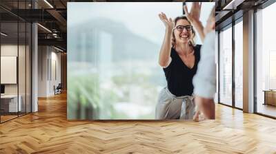 Businesswoman giving a high five to a colleague in meeting Wall mural