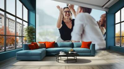 Businesswoman giving a high five to a colleague in meeting Wall mural