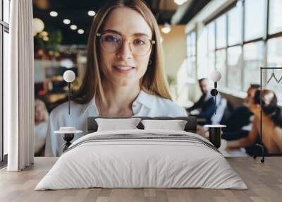 Businesswoman smiling at the camera in a co-working space Wall mural