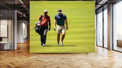 Caddy and golfer walking together on a sunny day, discussing strategy on the golf course during a competition Wall mural