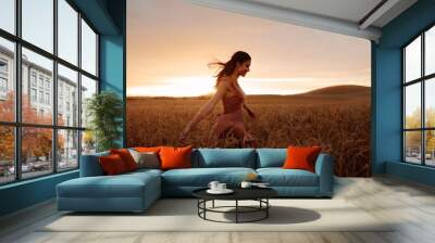 Carefree female strolling in the wheat field Wall mural