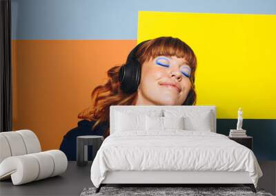 Carefree woman listening to relaxing music with geometric shapes in the background Wall mural