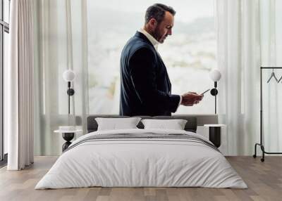 CEO using mobile phone in hotel room Wall mural