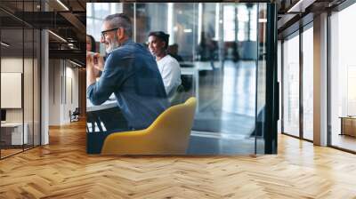 Cheerful businessman attending a meeting with his team Wall mural