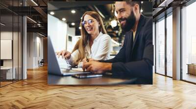 Cheerful businesspeople using a laptop in an office Wall mural