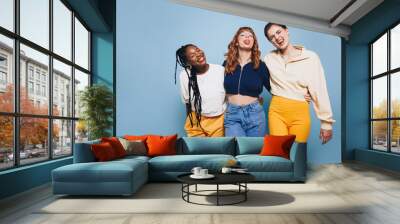 Cheerful female friends making funny faces while standing together in a studio Wall mural