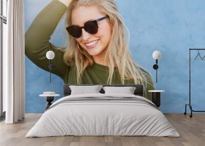 Cheerful young female model with sunglasses Wall mural