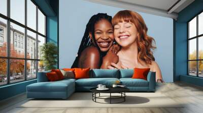 Cheerful young women with different skin tones smiling while standing together Wall mural