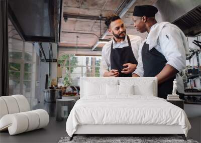 chefs talking while cooking food in commercial kitchen Wall mural