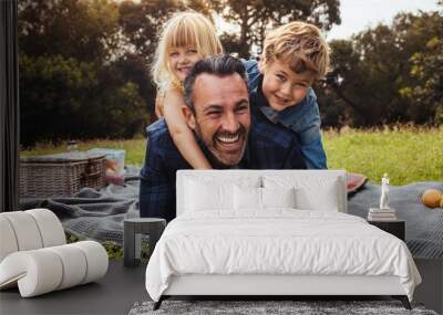 Children playing with their father on picnic Wall mural