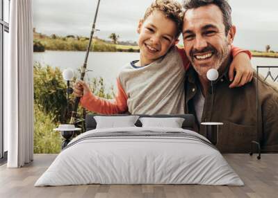 Close up of father and son fishing near a lake Wall mural