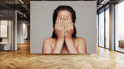 Close up of woman hiding her face with hands Wall mural