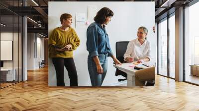 Colleagues discussing and working together in office Wall mural