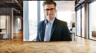 confident mature businessman standing in office Wall mural