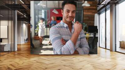 Confident young man standing in his office Wall mural