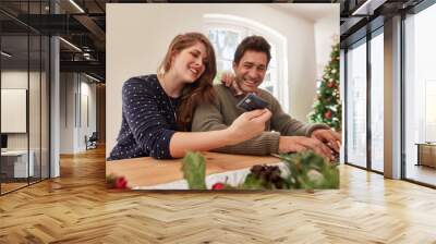 Couple doing online shopping for christmas Wall mural