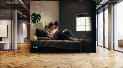 Couple on bed reading book Wall mural