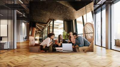 Creative business team using laptop during meeting Wall mural