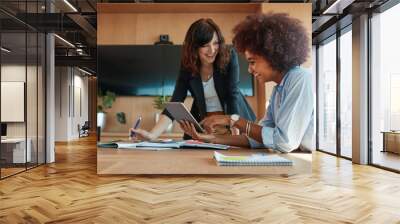 Creative female executives using digital tablet in office Wall mural