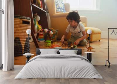 Cute young boy playing with colourful animal toys. at home Wall mural