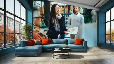 Diverse businesspeople holding a meeting in a modern workplace Wall mural