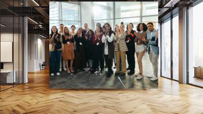 Diverse group of professionals applauding at a conference during corporate training session in a modern office setting Wall mural