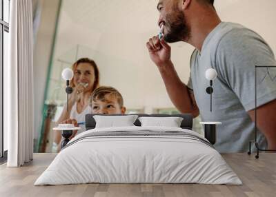 Family brushing teeth together in bathroom Wall mural