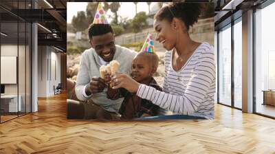 Family enjoying eating ice-cream on beach Wall mural