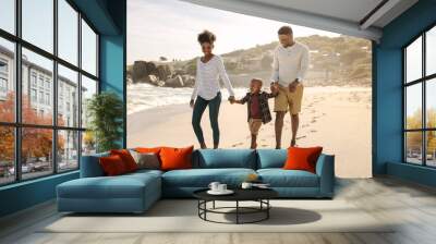 Family with son walking along the beach Wall mural