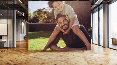 Father and son sitting in park Wall mural