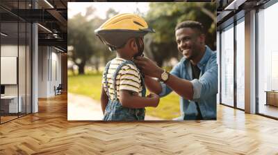 Father helping his son to wear a cycling helmet Wall mural