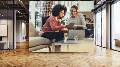 Female coworkers discussing work in office Wall mural