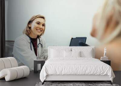 Female doctor listening to her patient during consultation Wall mural