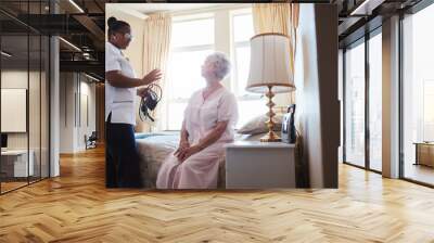 Female doctor visiting her senior patient at home Wall mural