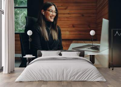 Female entrepreneur having an online meeting in a coworking space Wall mural