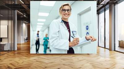 Female physician in hospital corridor writing prescription Wall mural