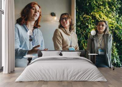 Female professionals engaged in productive discussion at a business conference Wall mural