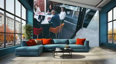 Female supervisor briefing her team in an office Wall mural